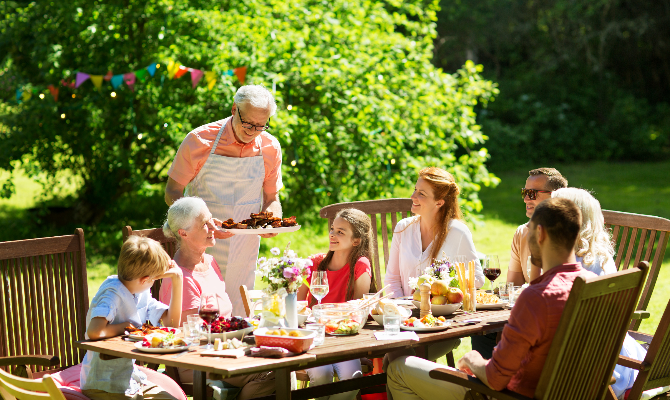 Family Having Dinner or Barbecue at Summer Garden