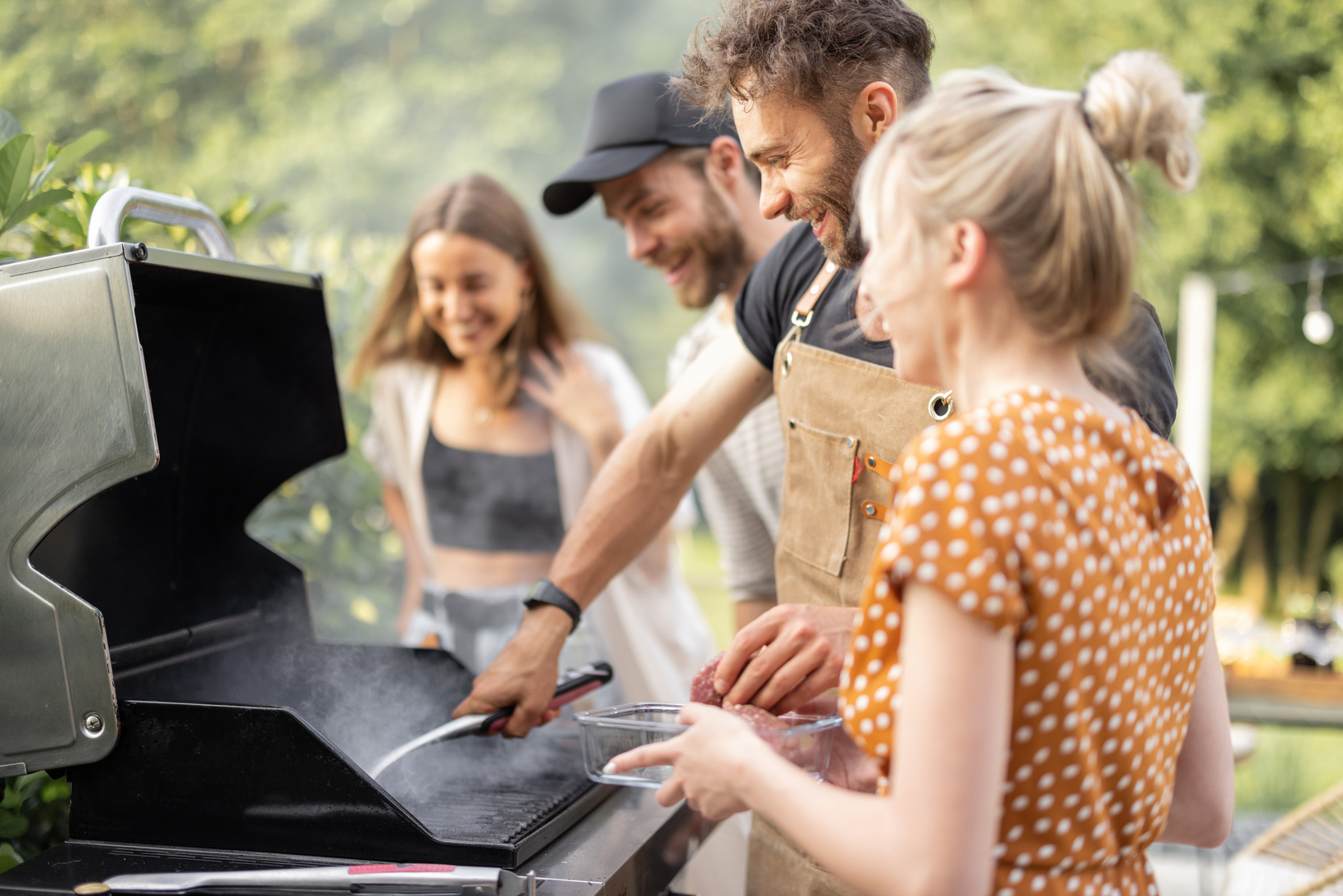 Friends Cooking on a Grill Outdoors